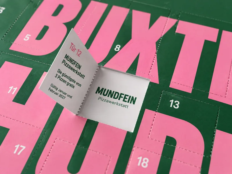 Tür 12: Pizza von MUNDFEIN, hinten der Gutschein, im Fenster der Partner